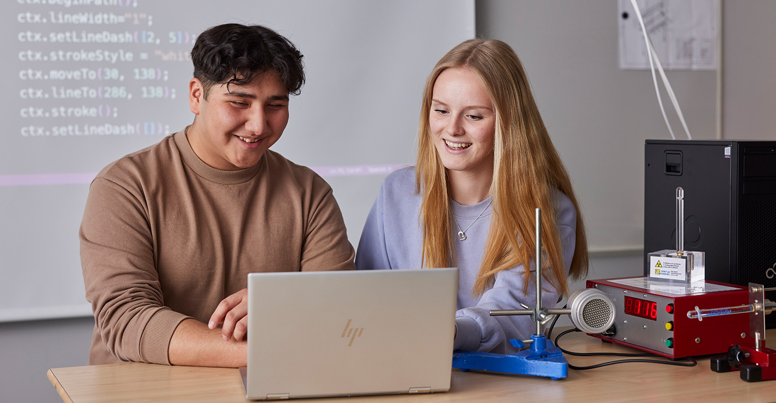 Två elever som jobbar vid en dator.